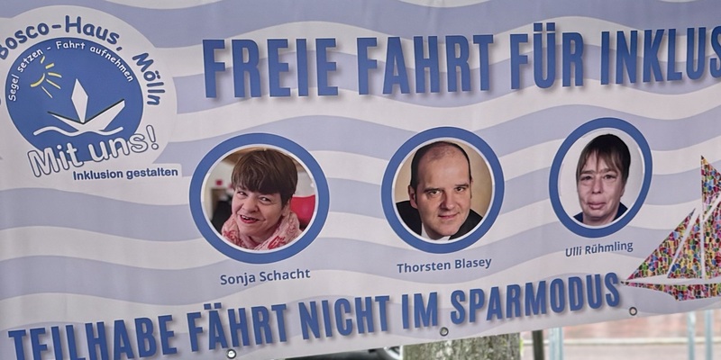 Transparent mit dem Text 'FREIE FAHRT FÜR INKLUSION' und 'TEILHABE FÄHRT NICHT IM SPARMODUS' sowie drei Porträtfotos von den Zeilgruppenvertretern von Mölln Inklusiv und dem Logo 'Dom Bosco-Haus Mölln Mit uns! Inklusion gestalten'